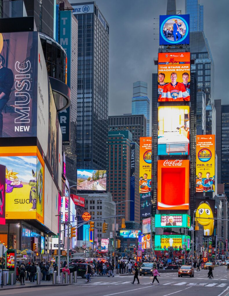 A bustling view of Times Square filled with bright, colorful billboards and lively street activity at night.