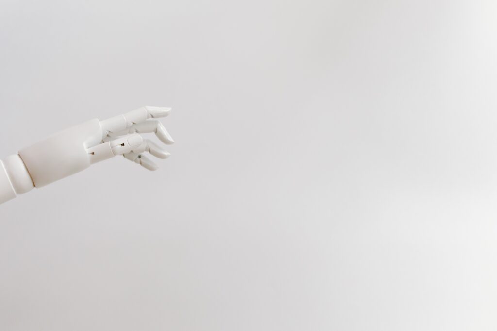 Minimalist image of a robotic hand reaching out on a white background.