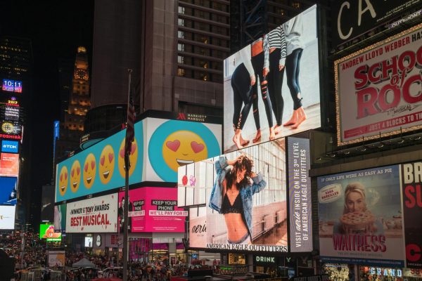 Colorful billboards light up New York City's iconic Times Square at night, with vibrant ads and bustling crowds.