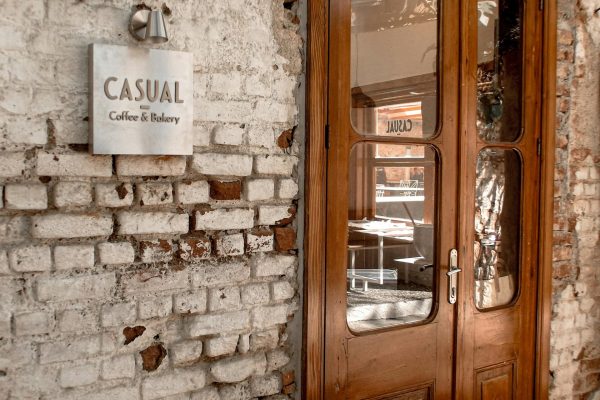 Rustic cafe entrance with wooden doors and vintage bricks, perfect for cozy coffee moments.