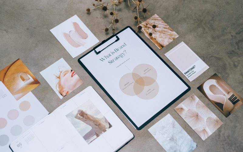 Flat lay of a minimalist brand strategy moodboard on a concrete surface.